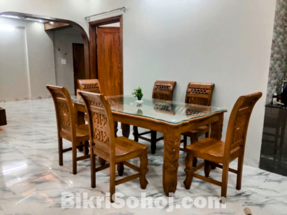 সেগুন কাঠের ছয় চেয়ারের একটি ডাইনিং টেবিল